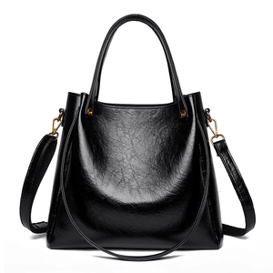Elegant black oil-wax leather tote bag with gold hardware and a detachable strap