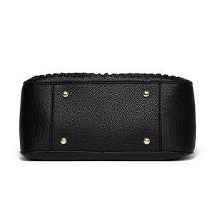 Bottom view of black pebble leather handbag with four gold metal protective feet