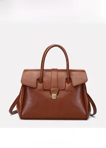 Detailed close-up of retro brown leather tote with elegant golden shield lock and texture