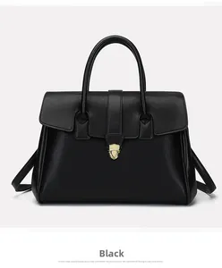 Detail of black pebbled leather tote bag with elegant gold buckle and shoulder strap