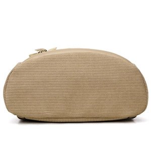 Bottom view of khaki corduroy anti-theft backpack showing oval base and textured fabric