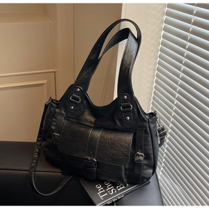 Close-up of black retro tote bag showing premium litchi grain texture and silver buckles