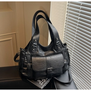 Macro view of black vintage tote bag texture with silver buckle and flap pocket detail