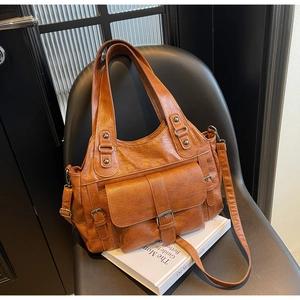 Detailed texture of brown retro tote bag with buckle pocket on a black chair