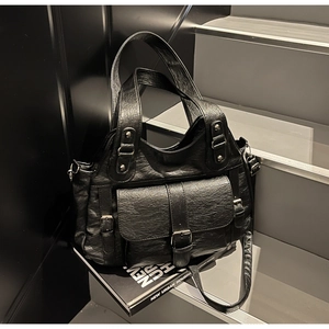 Detail of black oil-wax leather handbag with retro buckle pocket on urban stairs