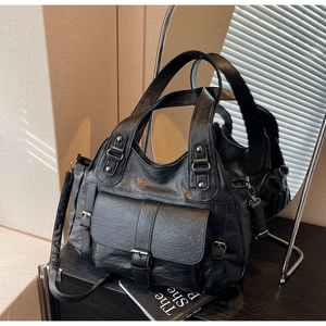 Detail of vintage black soft PU leather handbag with metal buckles and reinforced straps