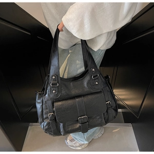 Detail of vintage black large capacity tote bag with functional pockets and metal buckle