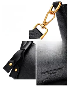 Detail of lychee textured black leather bucket bag with gold-tone metal hardware hooks