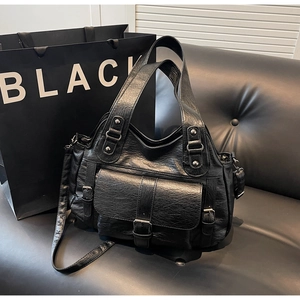 Detail of vintage black leather handbag with pleated texture and silver hardware