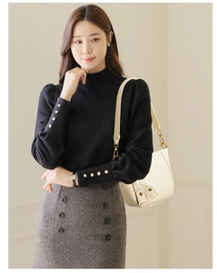 Chic cream leather bucket bag paired with elegant grey herringbone skirt and black sweater