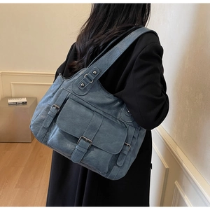 Close-up of blue vintage multi-pocket shoulder bag in high-quality faux leather finish