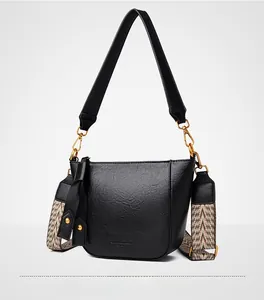 Detail view of black lychee leather bucket bag with golden hardware and dual straps