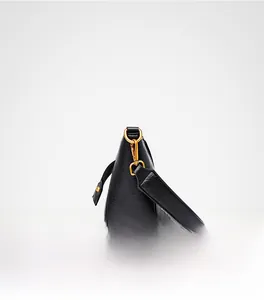 Side view of black textured leather bucket bag with premium gold metal buckle detail