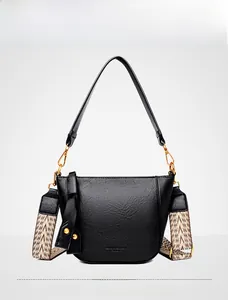 Detail of black lychee grain leather bucket bag with stylish herringbone wide strap