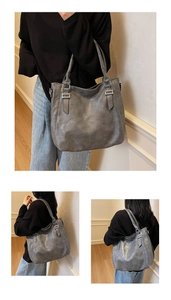 Detail of grey PU tote bag with vintage pleated texture and silver buckle hardware