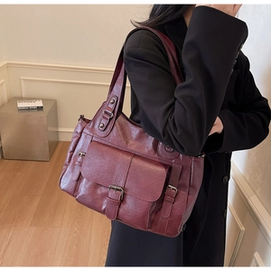 Close-up of burgundy vintage tote bag featuring a buckle pocket and pleated texture leather