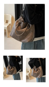 Detail of a brown vintage tote bag showing soft leather texture and handle strap