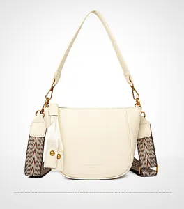 Cream white bucket bag with a wide ethnic style woven strap and vintage gold hardware
