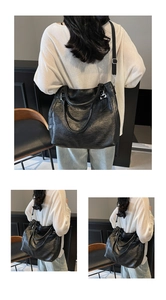 Close-up of black faux leather tote bag with silver hardware and adjustable strap