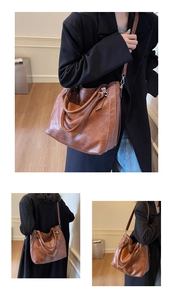 Detail view of a large brown leather tote bag showing side buckle and spacious interior design