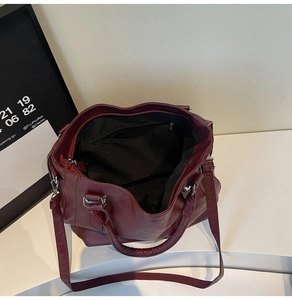 Detailed top view of a burgundy leather tote bag with inner compartments and a zipper pocket