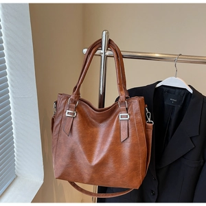 Detail view of large brown vintage tote bag with adjustable strap and metal hardware