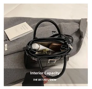 Vue intérieure du sac à main noir montrant l'espace de rangement et poche zippée