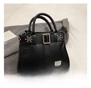 Détail du sac cabas en cuir grainé noir avec clous argentés et plaque logo