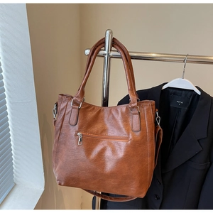 Detailed view of brown tote bag with zipper pocket and adjustable shoulder strap