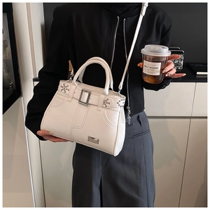 Détails du sac à bandoulière blanc avec rivets, boucles en métal et texture cuir lisse