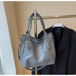 Detail of grey tote bag showing wrinkled PU texture, silver hardware and detachable strap