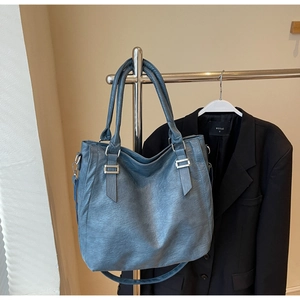 Detail view of deep blue tote bag with vintage texture and silver hardware
