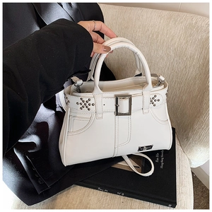 Vue détaillée du sac à main blanc clouté avec boucle argentée et bandoulière réglable