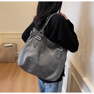Close-up of large charcoal grey tote bag with vintage leather texture and silver buckle detail