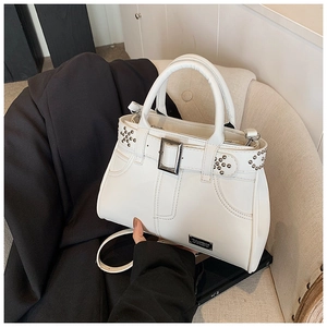 Gros plan du sac fourre-tout à rivets blancs avec boucle et texture cuir