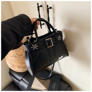 Détail du sac à main en cuir noir avec rivets argentés et bandoulière réglable pratique
