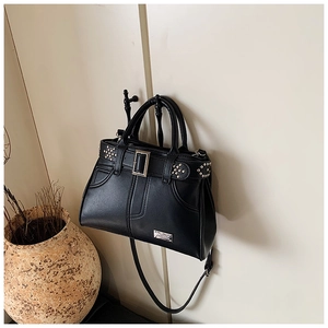 Détail d'un sac à main noir en similicuir avec rivets argentés et boucle en métal