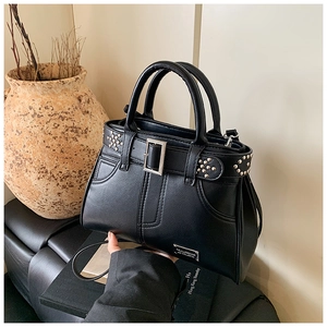 Détail du sac à main noir à rivets avec boucles argentées et bandoulière texturée