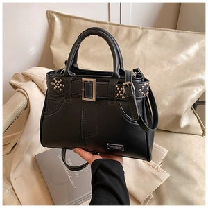 Détail du sac à main noir riveté avec boucles argentées et texture cuir de haute qualité