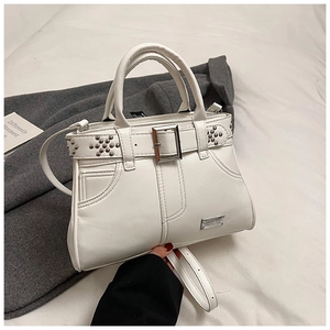 Vue détaillée du sac à main blanc avec rivets argentés et boucle de ceinture métallique