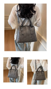 Detail view of deep grey vintage textured tote bag with decorative buckle straps