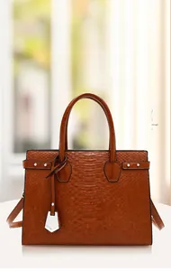 Detail view of the deep brown crocodile texture and silver hardware on this tote bag