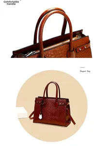 Detail of comfortable handle on dark red-brown tote bag with faux crocodile embossing