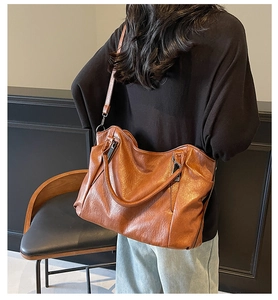 Detailed back view of a brown vintage leather tote bag with dual straps and soft texture