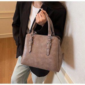 Detail of taupe retro tote bag with dual handles and silver buckle for daily commuting