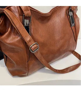 Detail of adjustable strap and leather texture on a brown retro tote bag
