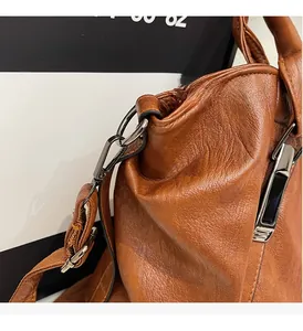 Detailed shot of dark gunmetal hardware and premium brown leather texture on a tote bag