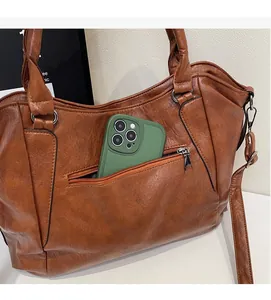 Close-up of brown PU leather tote with a functional back zipper pocket for smartphones