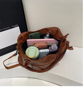 Interior view of spacious brown leather crossbody bag filled with daily essentials