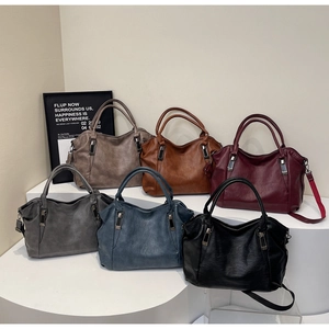 Six assorted colors of textured leather tote bags displayed in a tiered fashion